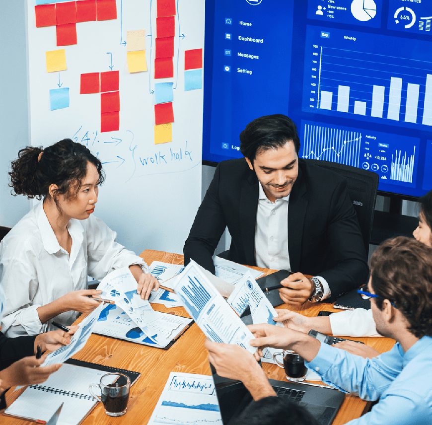 A team discusses data charts in a meeting room.